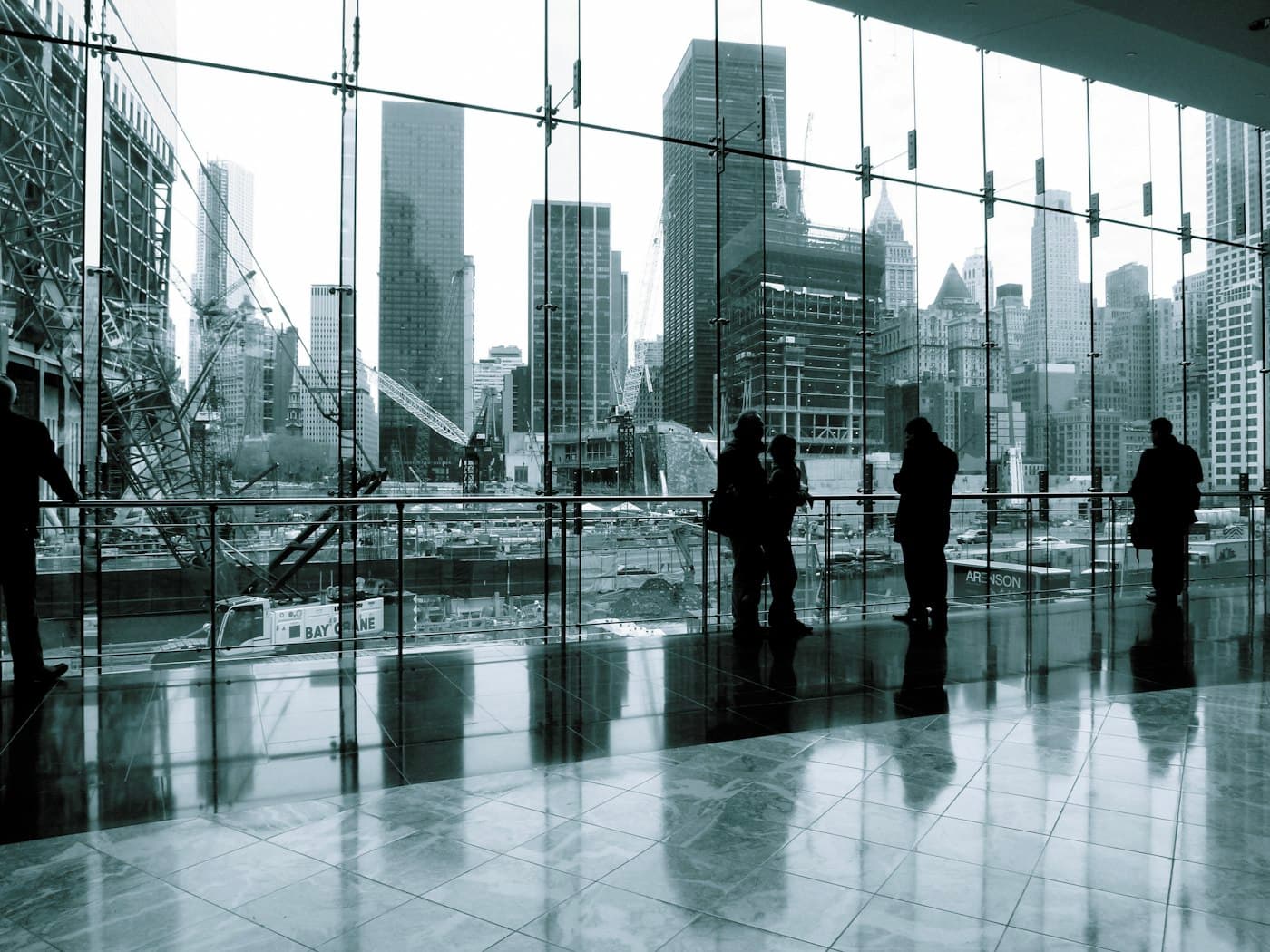Visitors talking beside a glass facade