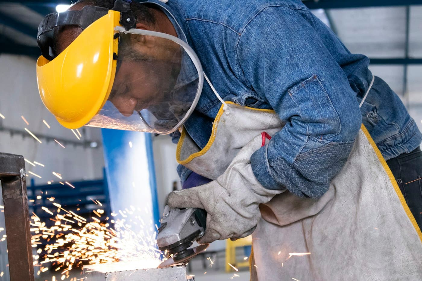 Worker grinding metal with a face shield